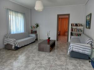 a living room with two couches and a coffee table at Flisvos House in Megalochori