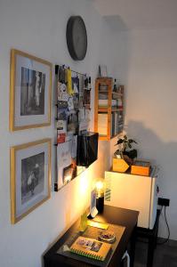 Habitación con mesa y pared con cuadros. en B&B Li Gutti en Aieta