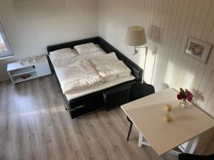 um pequeno quarto com uma cama e uma mesa em Kattalängan - Lilla huset em Brösarp
