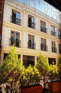 - un bâtiment avec des balcons et des arbres en face dans l'établissement BALPETEK HOTEL, à Istanbul