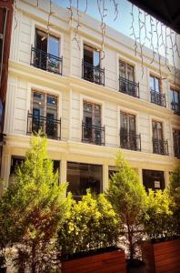 un edificio con balcones y árboles delante de él en BALPETEK HOTEL, en Estambul