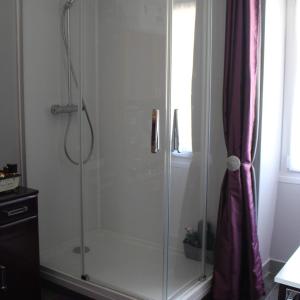 a shower with a glass enclosure in a bathroom at La Demeure de Cathy in Agneaux