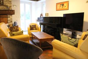 a living room with yellow chairs and a piano at La Demeure de Cathy in Saint Lo