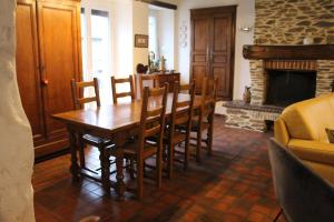 a dining room with a table and chairs and a fireplace at La Demeure de Cathy in Saint Lo