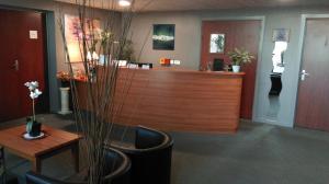 a lobby with a reception desk with chairs and a table at Résidence VILLA DES MARAIS in La Chevrolière