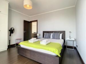 Un dormitorio con una cama grande con toallas. en Sunny Side by Atlantic Holiday, en Madalena do Mar