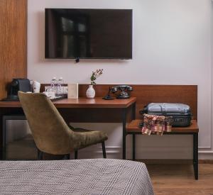 a desk with a chair and a suitcase on a table at Villa Flavia Heritage Boutique Hotel in Plovdiv