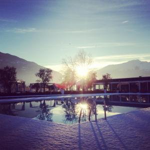 a bike parked next to a swimming pool with the sun at Seven Park Hotel Lake Como - Adults Only in Colico