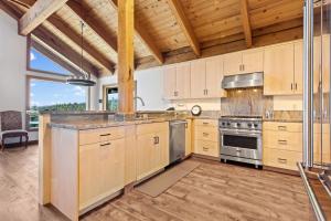 una cocina con armarios de madera y electrodomésticos de acero inoxidable en Beautiful Remodel with Chef's Kitchen - Sky High #14, en Bear Valley