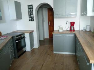 kuchnia z szarymi szafkami i drewnianą podłogą w obiekcie Hostel Tulip - pokój nr 8 ze wspólną łazienką i kuchnią w Szczecinie