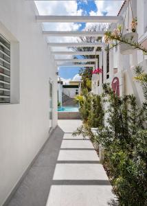 ein weißes Haus mit einer Pergola und einem Gehweg in der Unterkunft Rosalina Ocean Park in San Juan