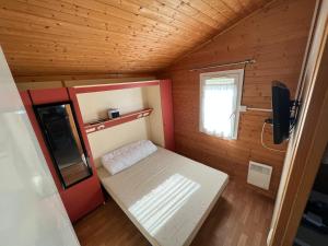 Cette petite chambre comprend un lit et une fenêtre. dans l'établissement Chalet agréable en bord en de mer., à Le Port-des-Barques