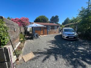 une voiture garée dans l'allée d'une maison dans l'établissement Chalet agréable en bord en de mer., à Le Port-des-Barques