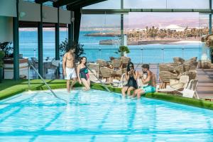 a group of people sitting in a swimming pool at Arrecife Gran Hotel & Spa in Arrecife