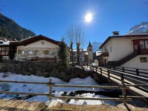 un pueblo en las montañas con nieve en el suelo en Dolomites Holiday Home en Canazei