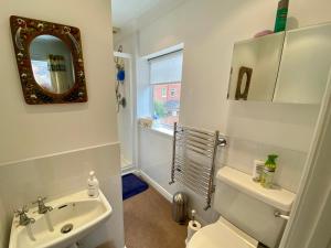 a bathroom with a sink and a toilet and a mirror at Spacious Two Bedroom House - TM in Southport +4 photos