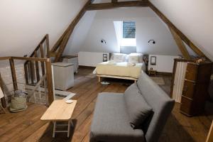 a living room with a couch and a bed at La maison au fil du temps in Pont-Rémy