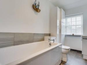 uma casa de banho branca com uma banheira e um WC em The Cottage on Fairbank - Kirkby Lonsdale em Kirkby Lonsdale