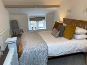 um quarto com uma cama grande e uma cadeira em The Cottage on Fairbank - Kirkby Lonsdale em Kirkby Lonsdale
