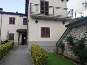 a white building with a balcony and a yard at Il Roseto in Coppito