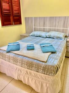 a bed with two blue pillows on top of it at Pousada e Chalés Recantos do Mar in Barra Grande +122 photos