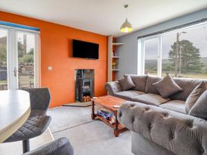 a living room with a couch and a table at Bryn Hyfryd in Talsarnau