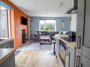 a kitchen and living room with a couch at Bryn Hyfryd in Talsarnau
