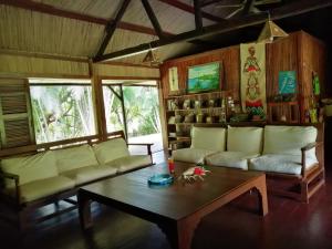 a living room with a couch and a coffee table at Chambres d'hôtes Villa Les Orchidées Chez Ago in Sainte Marie