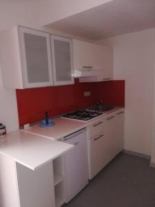 uma cozinha com armários brancos e um forno com placa de fogão em Casetta Mandarino em Ischia