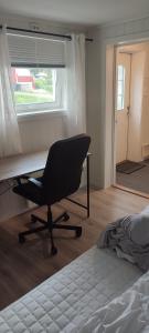 een slaapkamer met een bureau en een stoel naast een bed bij Koselig leilighet 100m fra E6 in Fauske