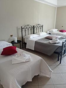 a bedroom with two beds with white sheets and red pillows at Il Roseto in Coppito +25 photos