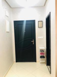 una puerta negra en un pasillo con un zapatero en L impérial appart haut founty en Agadir