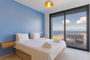 a bedroom with a bed with a view of the ocean at Casa Mozart I in Estreito da Calheta +28 photos