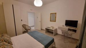 a bedroom with a bed and a desk and a television at Maison D’aMi’ in Termoli