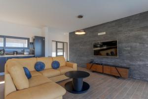 a living room with a couch and a tv at Casa Mozart I in Estreito da Calheta