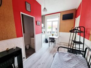 a room with red walls and a bed and a desk at Les Madeleines de Saint-Omer in Saint-Omer