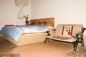 a bedroom with a bed and a table with a laptop at La paillotte gorilla place kinigi in Kinigi