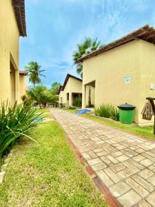 a brick road next to a building with palm trees at Pousada e Chalés Recantos do Mar in Barra Grande