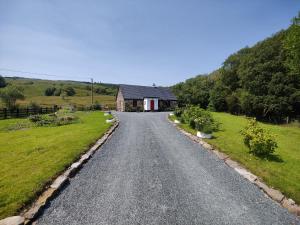 uma estrada que leva a uma casa num campo em Carraun Cottage em Manorhamilton