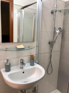 a bathroom with a sink and a shower with a mirror at Il Piccolo Albergo Matera in Matera