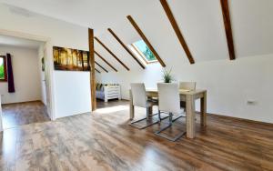 a dining room with a table and white chairs at Apartman Doris in Rakovica