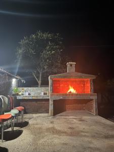 a brick oven with a fire in it at night at Shuko Village House in Sarandë