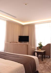 Cette chambre comprend un grand lit et une table. dans l'établissement قوت المصيف للشقق الفندقية, à Hotat bani tamim