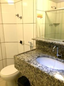 uma casa de banho com um lavatório, um WC e um espelho. em Hotel Veraneio em Recife