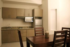 Una cocina con una mesa de madera y una mesa y sillas. en MARENA Suites & Apartments, en Mazatlán