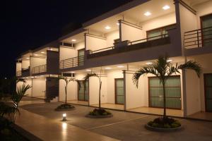 un edificio con palmeras delante de él por la noche en MARENA Suites & Apartments, en Mazatlán