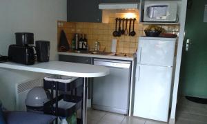 eine kleine Küche mit einem weißen Kühlschrank und einer Theke in der Unterkunft résidence le hameau du moulin -- chemin de Gouny 24290 montignac- DORDOGNE in Montignac