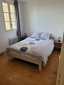 1 cama en un dormitorio con suelo de madera en la petite montagne, en Le Puy-Notre-Dame