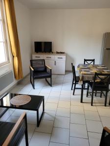 a living room with a table and chairs at la petite montagne in Le Puy-Notre-Dame