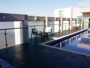 a balcony with a table and chairs next to a swimming pool at Ecusuites Studio Two Riverfront con Jacuzzi Hidro Privado in Guayaquil